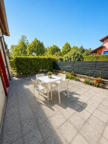 a white table and chairs on a patio at Villa Dascia - Agenzia Cocal in Caorle