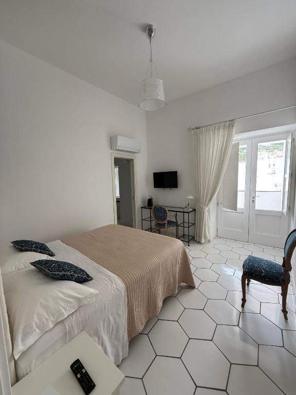 a bedroom with a bed and a table and a television at Casa Stinga in Capri