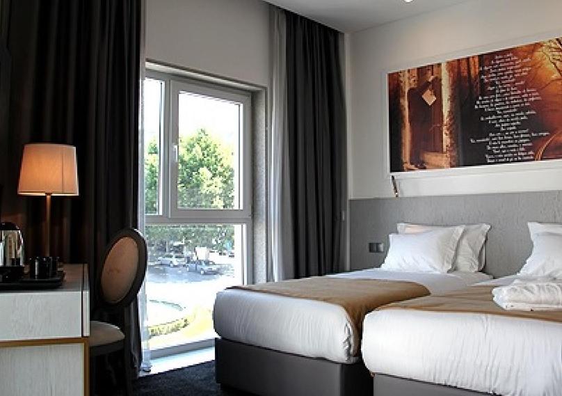 a hotel room with a bed and a window at Hotel José Régio in Portalegre