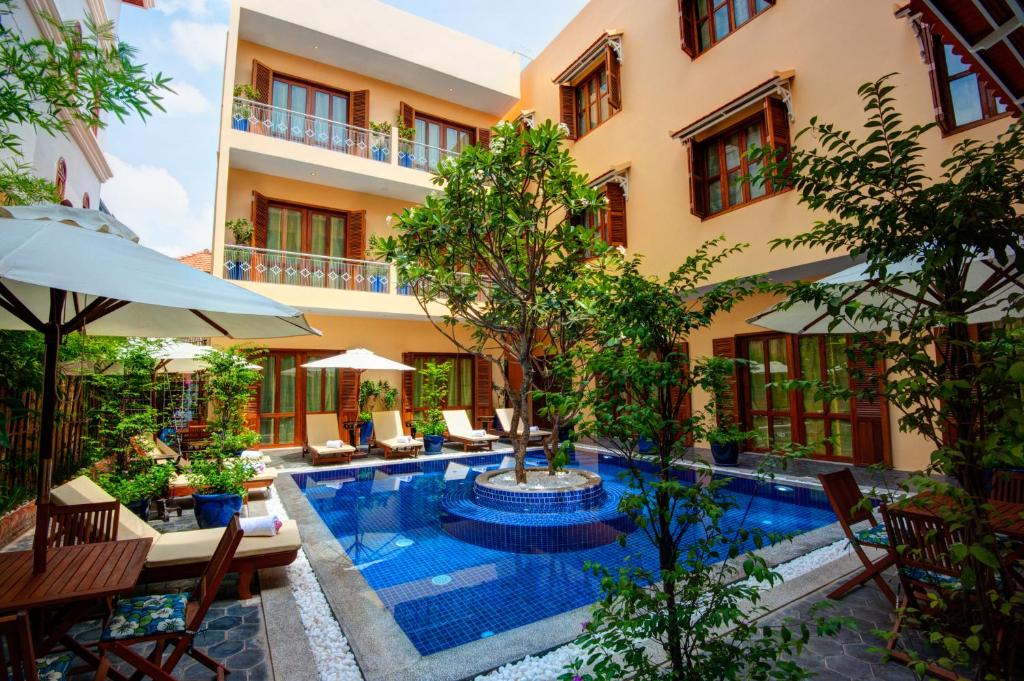 a courtyard with a swimming pool in front of a building at House Boutique Eco Hotel in Phnom Penh
