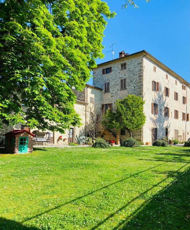 a large building with a grassy yard in front of it at Agriturismo Del Casato in Sansepolcro