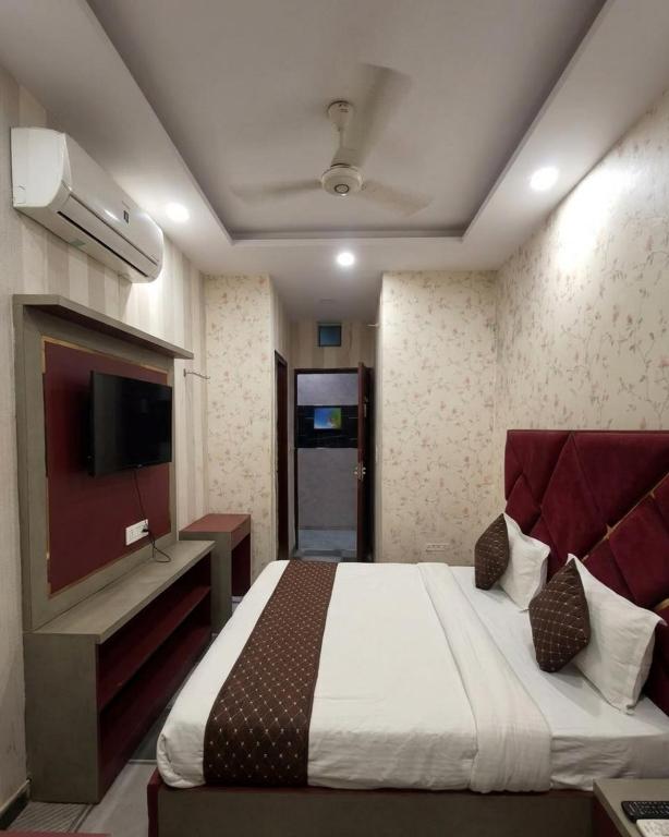 a bedroom with a bed and a flat screen tv at Cloud Cobe in New Delhi