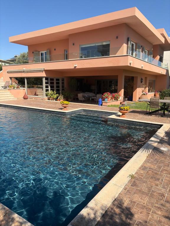 a house with a swimming pool in front of a house at Omma slow living villa in Rafina