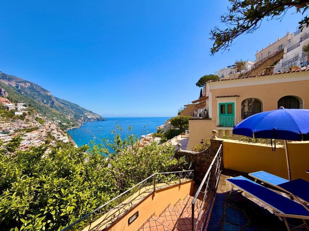 a view of the amalfi coast from a house with an umbrella at Casa Hellen Positano center in Positano