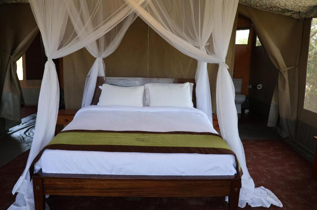 a bedroom with a bed with a canopy at Treasure camp in Maasai Mara National Reserve