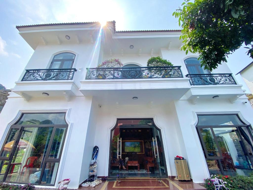 a white building with a balcony on top of it at Thành Đạt Homestay Cát Bà in Cat Ba