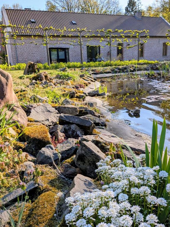 a garden with rocks and flowers in front of a building at Aska Logies vakantiewoning in As
