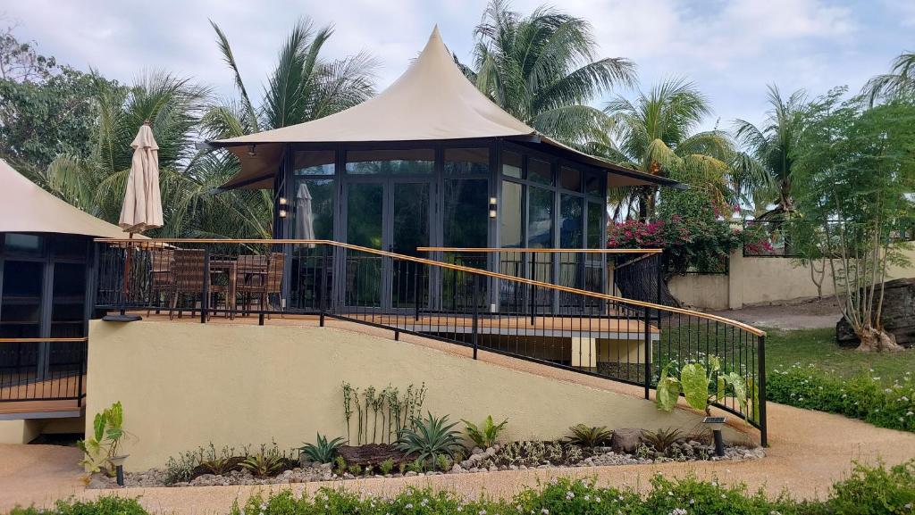 a gazebo with a table and a umbrella at The Halfway Cafe-Dauin, Glamp1 - Cricket in Dauin