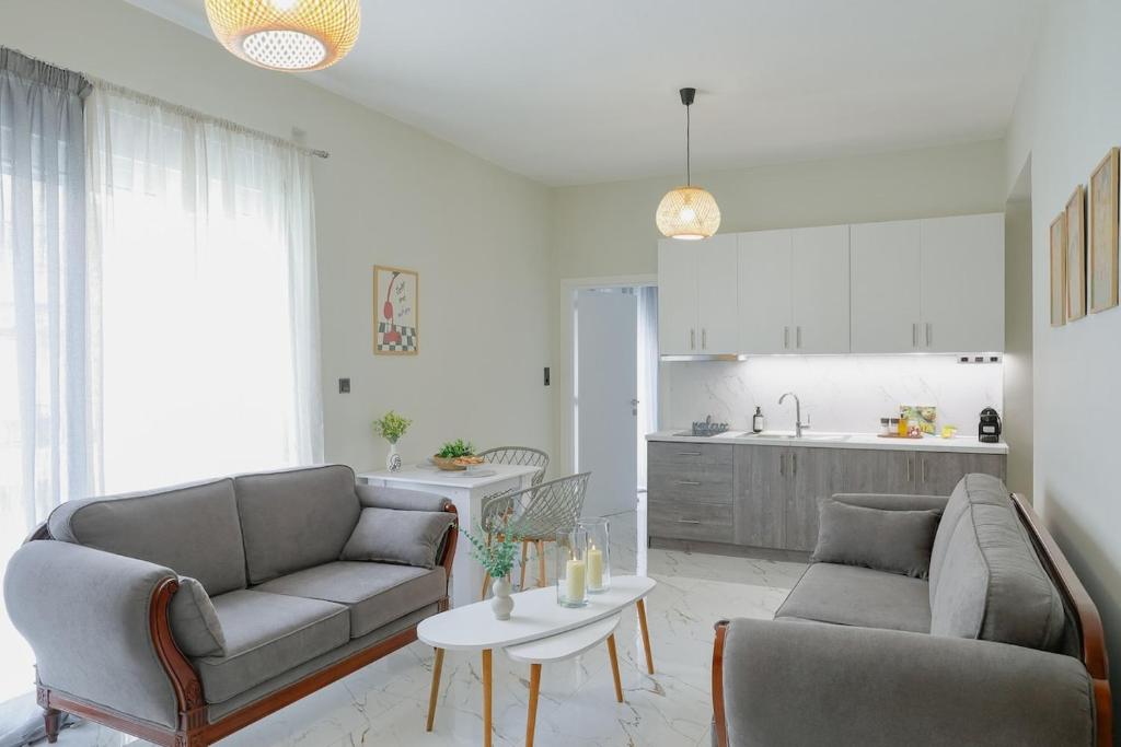 a living room with two couches and a table at Aphrodite Old Town Suite Xanthi in Xanthi