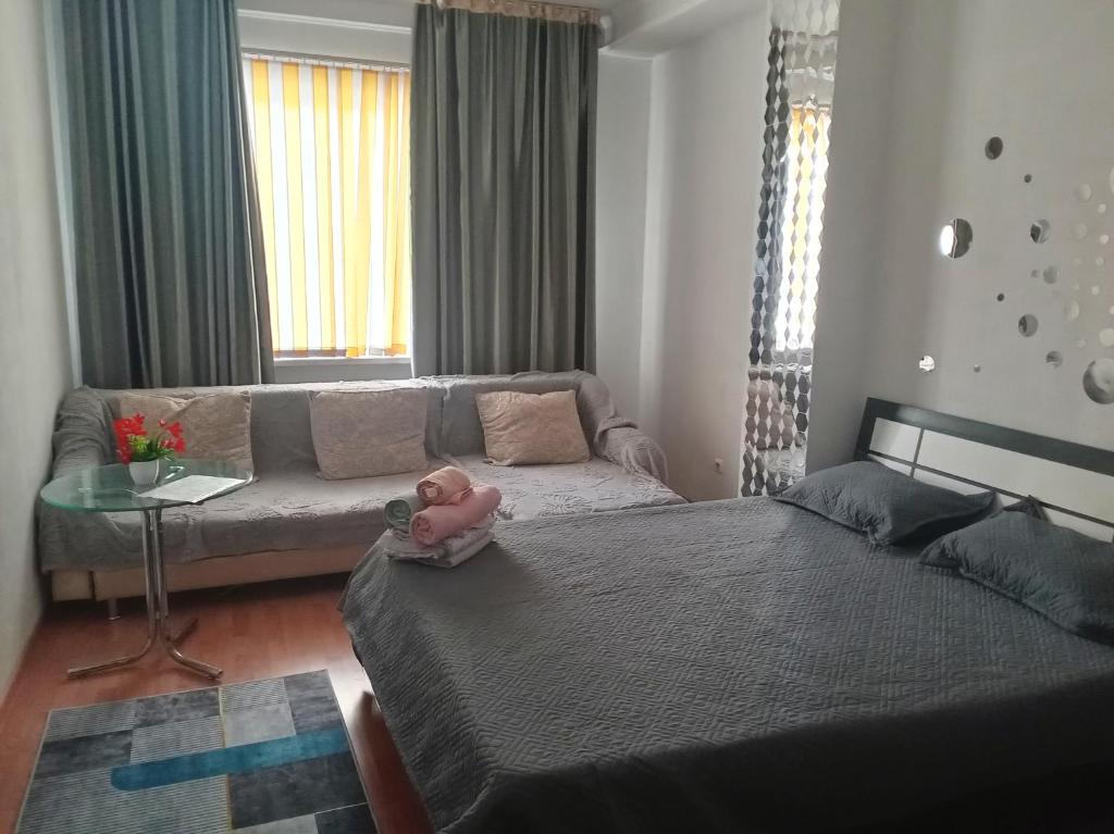 a living room with a couch and a doll on a bed at Абай2 169 in Astana