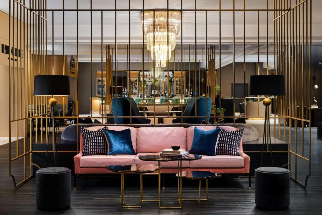 a living room with a pink couch and a table at The Gwen, a Luxury Collection Hotel, Michigan Avenue Chicago in Chicago