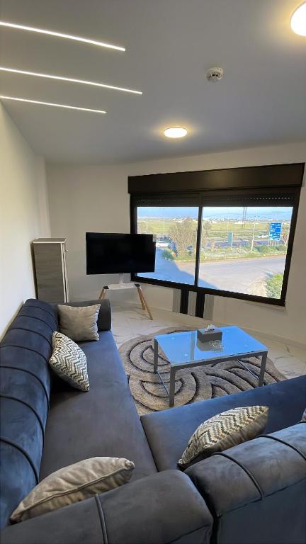 a living room with a blue couch and a table at Airport sky in Amman