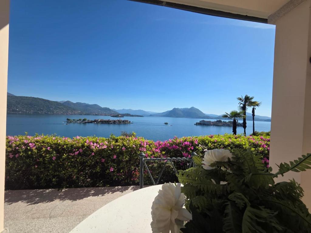 a room with a view of the water and flowers at Queen Apartment - Stunning Panoramic Island View in Baveno