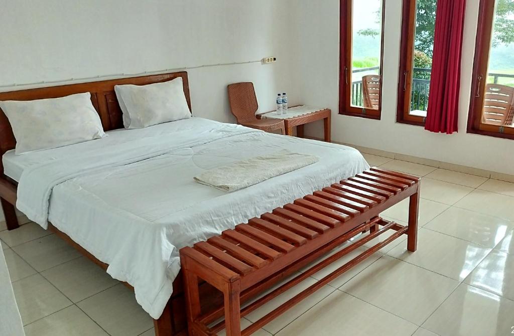 a bedroom with a large bed and a bench in it at Filomena Lodge in Ende