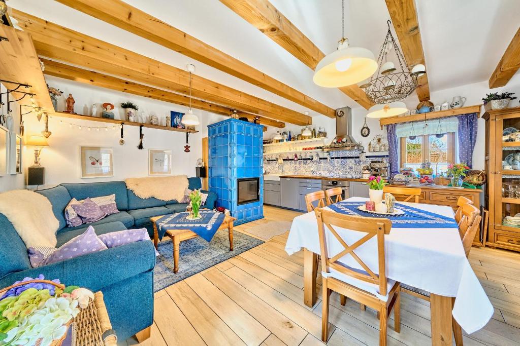 a living room and kitchen with a blue couch and a table at Wellness & Golf Chaloupka Ovčárna in Nová Bystřice