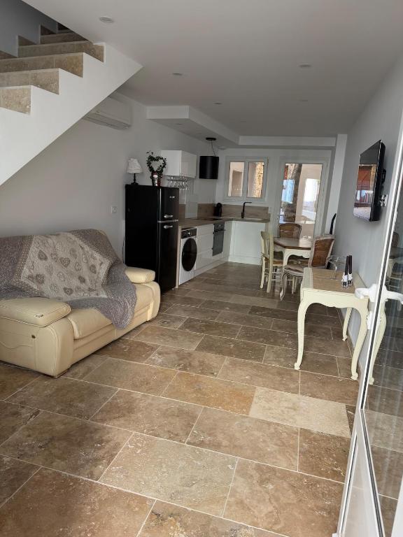 a living room with a couch and a kitchen at Les remparts de Sasha in Lapalme