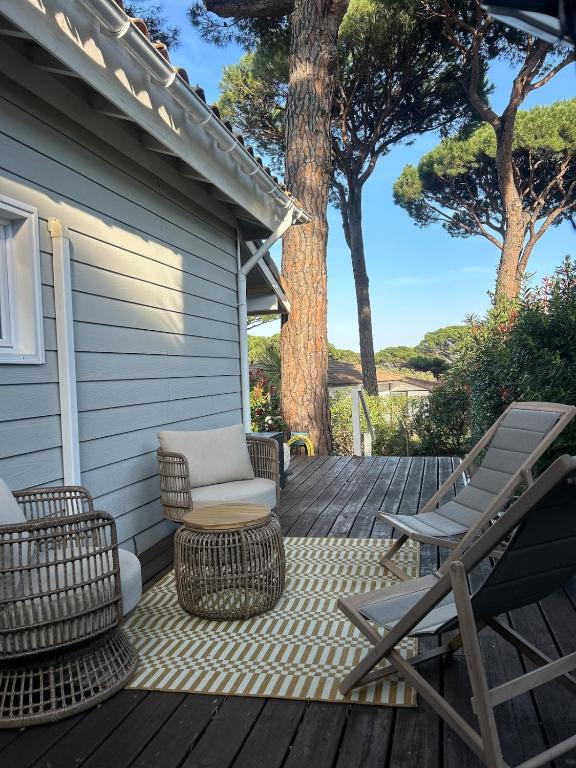 a deck with two chairs and a table and chairs at Californian style chalet in Gassin