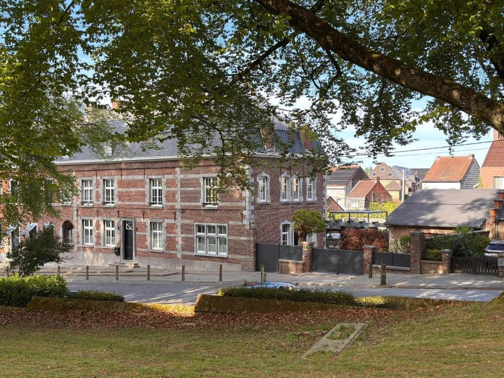a large brick building with a courtyard in front of it at La Porte Noire in Courcelles