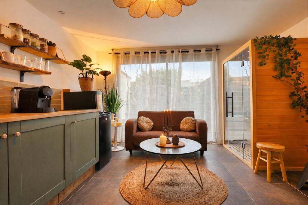 a living room with a couch and a table at L'Ecrin des Monts in Bailleul