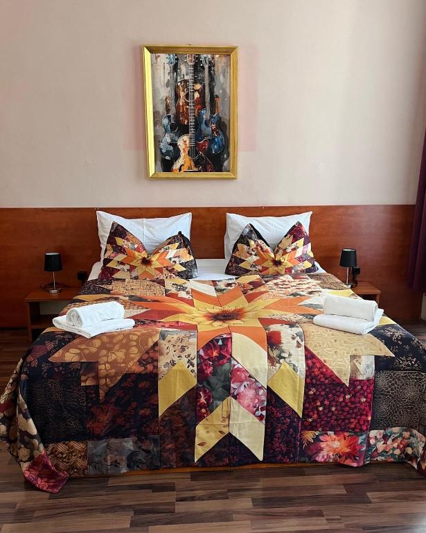 a bed with a quilt on top of it at Pension Madara in Vienna