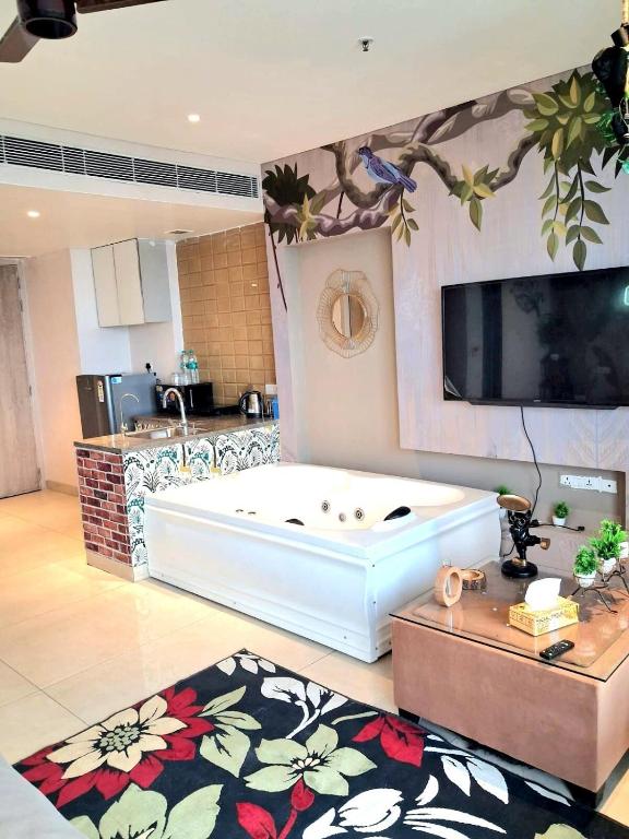a large white tub in a room with a kitchen at Nature Escape Jacuzzi Apartment in Gurgaon