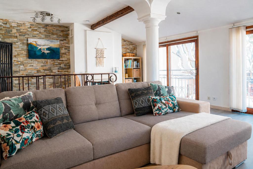 a living room with a brown couch with pillows at La Mouette Bleue maison de ville individuelle et climatisée in Martigues