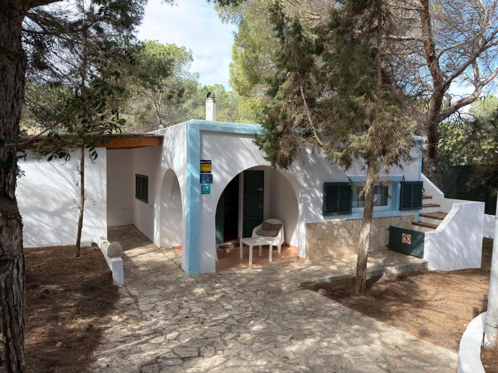 a white house with a chair in front of it at Casa Nena Es Calo in Es Caló