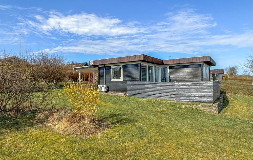 a small house sitting on top of a grass field at 2 Bedroom Stunning Home In Roslev in Roslev