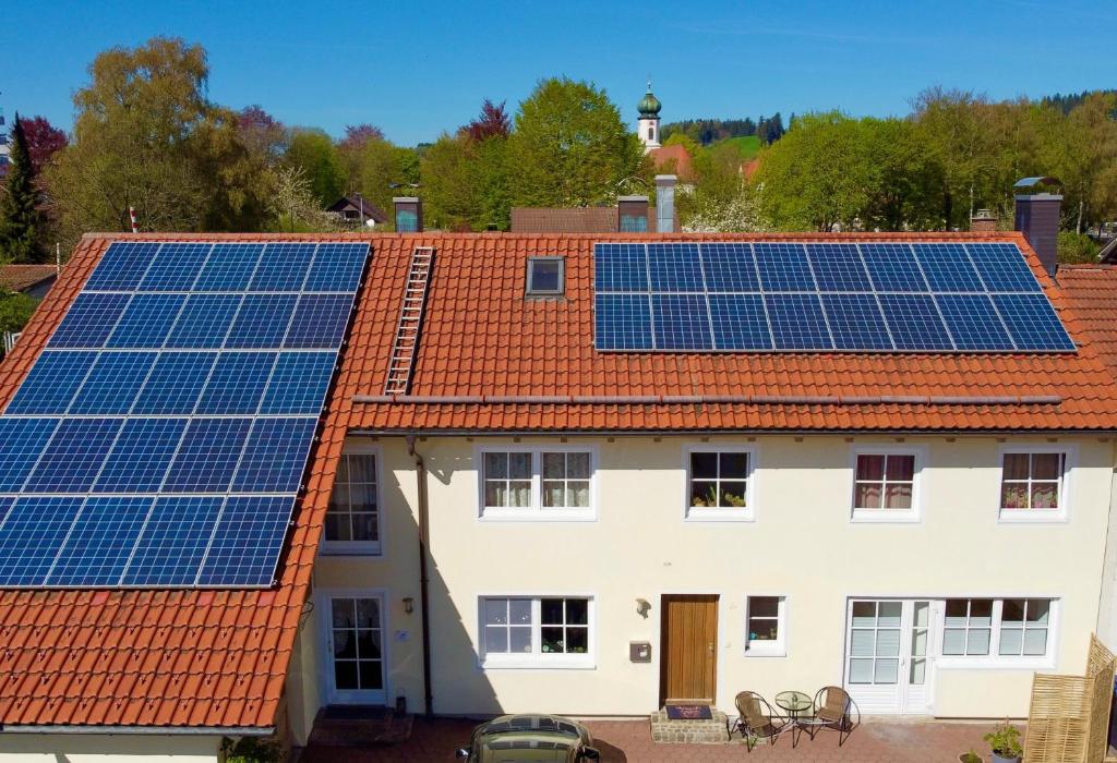 a house with solar panels on the roof at Alte Malerei in Peiting