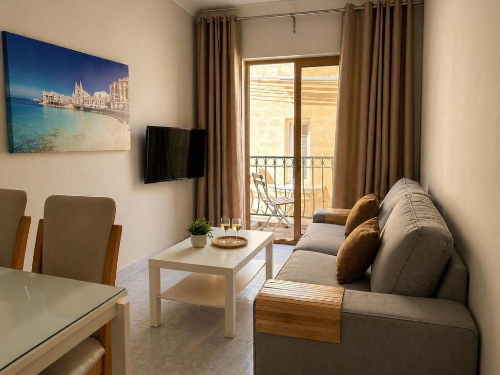 a living room with a couch and a table at City Center Apartments in Mellieħa