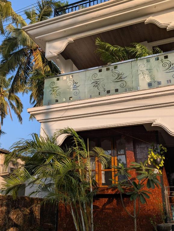 a building with a balcony with plants on it at Goa Paradise House in Canacona