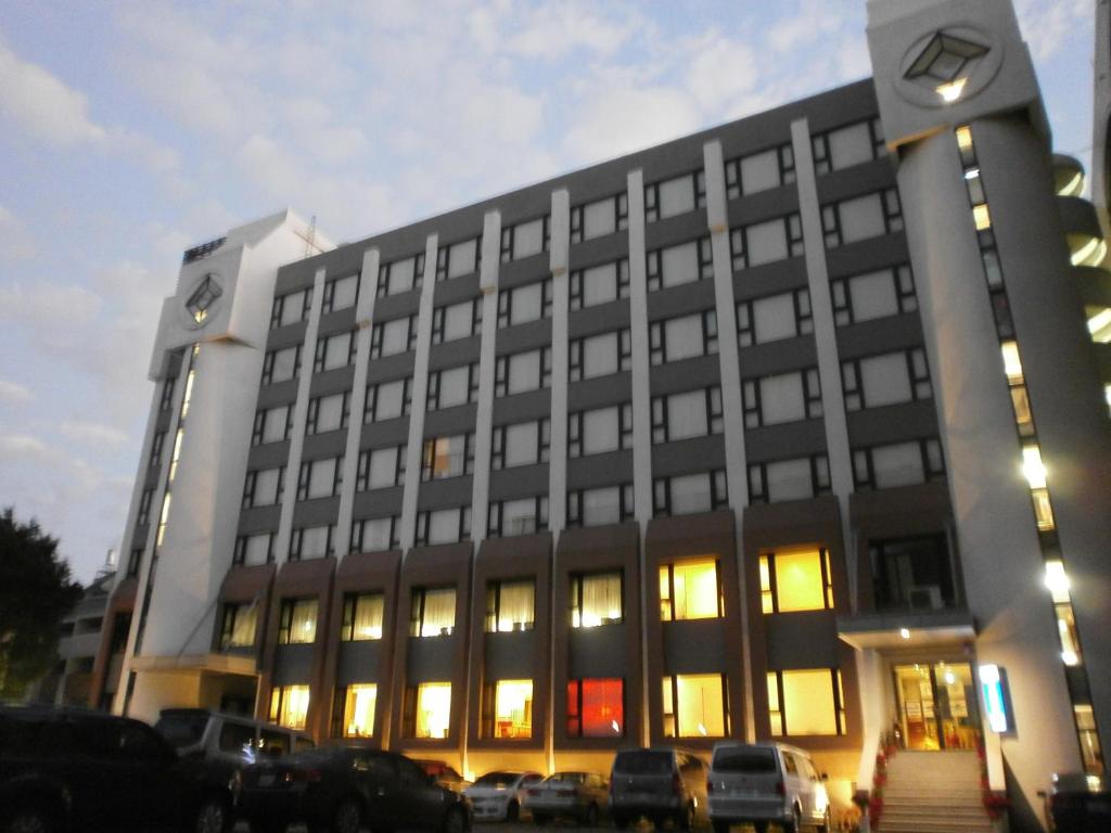 a large building with cars parked in front of it at Kaohsiung International Plaza in Kaohsiung