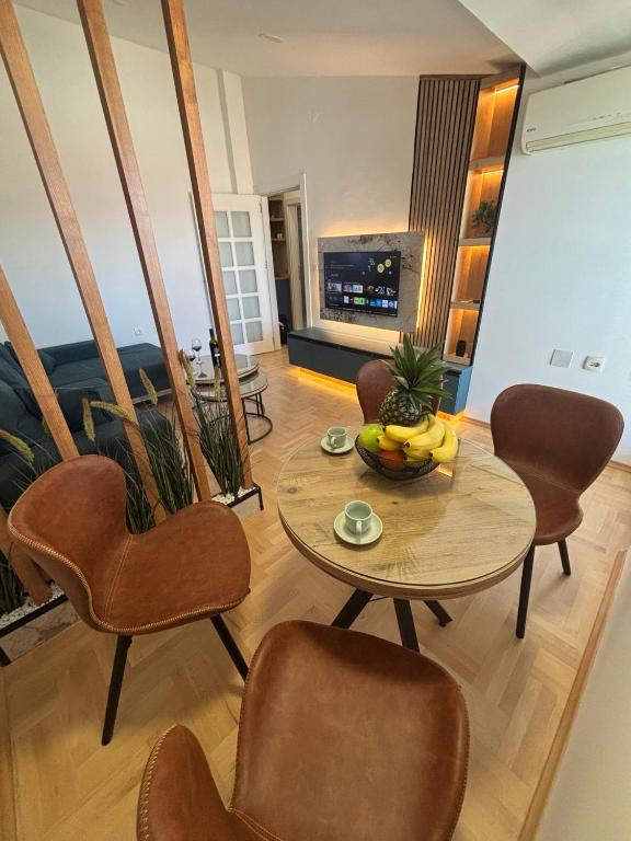 a living room with a table and chairs and a television at Puro Center in Ohrid