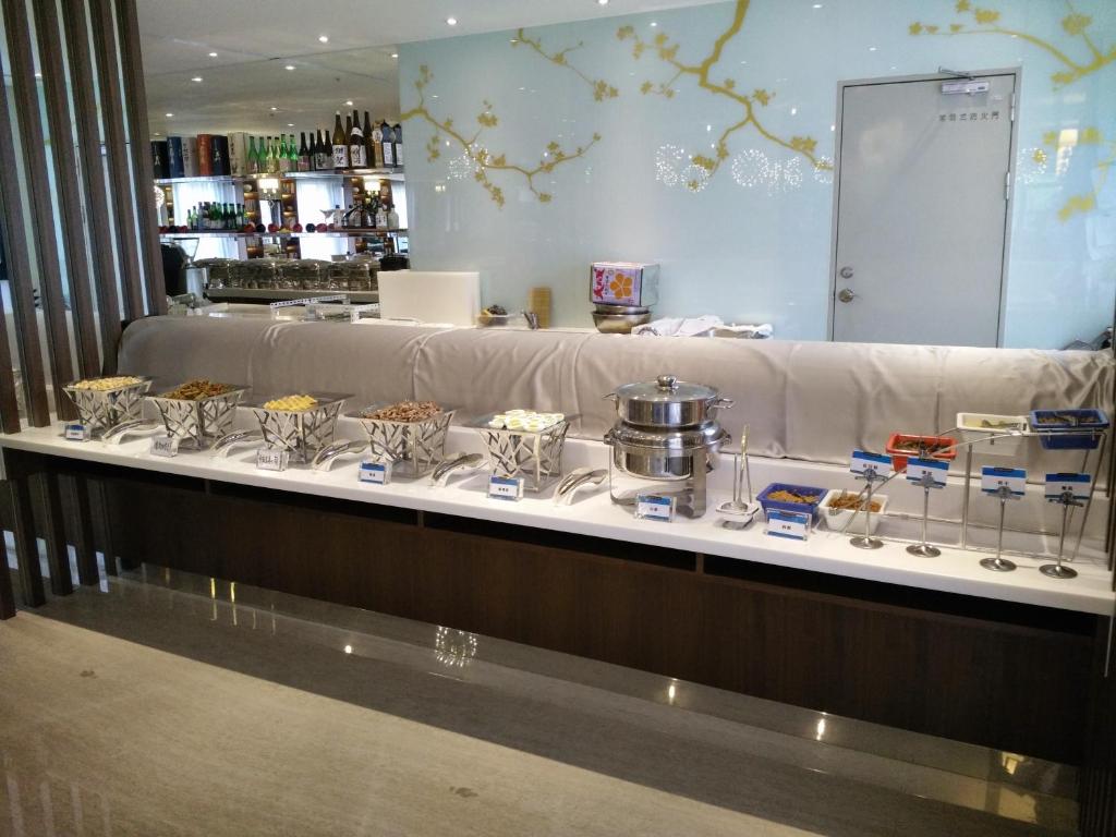 a buffet line with various food items on a counter at Kaohsiung International Plaza in Kaohsiung
