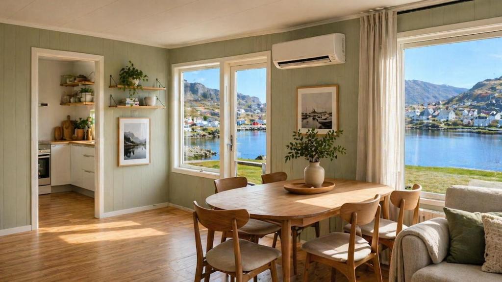 a dining room with a table and chairs and a large window at KB - Waterfront Villa Sørvågen in Moskenes