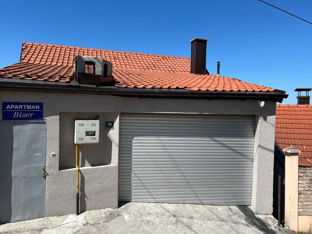 a garage with a roll up garage door on a house at Apartman Biser in Sarajevo