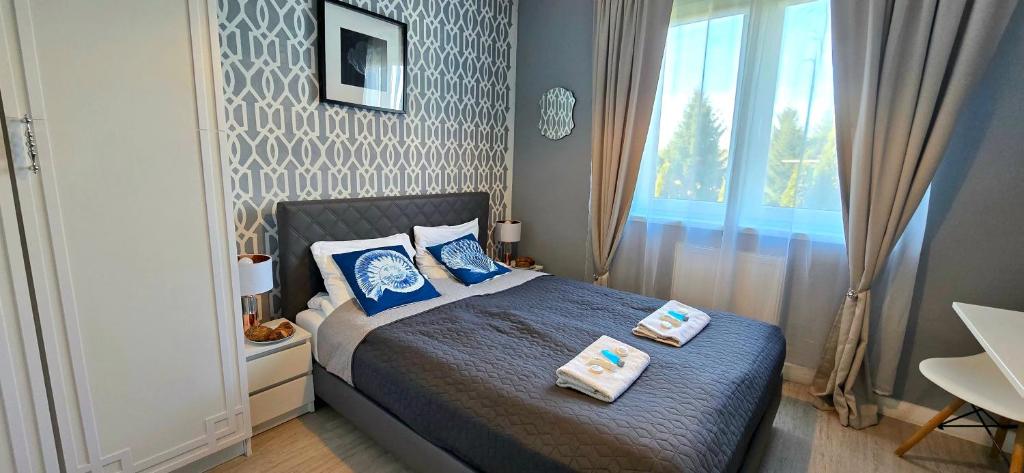 a bedroom with a bed with two pillows on it at Pokoje Syrenka by TriApart in Stegna