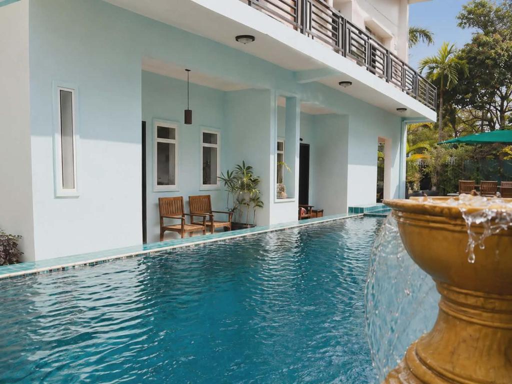 ein Schwimmbad mit Springbrunnen vor einem Haus in der Unterkunft Saba Lua Siem Reap in Siem Reap