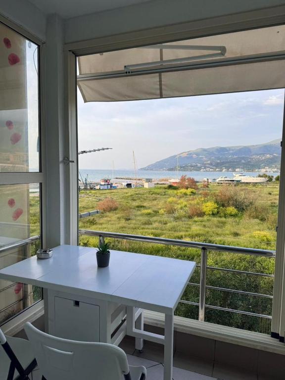 a white table and chairs in front of a window at Ioanian Évasion in Vlorë