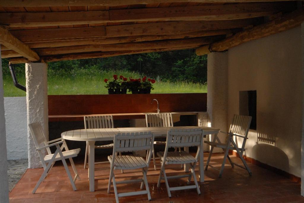 - une table et des chaises sur une terrasse couverte avec une table, une table et des chaises dans l'établissement Country Villa Altare, à Altare