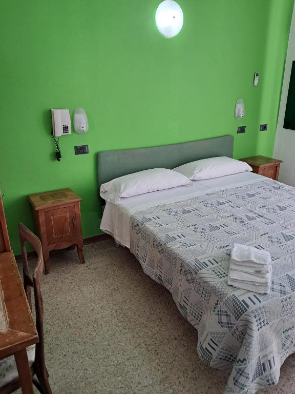 a bedroom with a bed with a green wall at Hotel Adriatico in Bellaria-Igea Marina