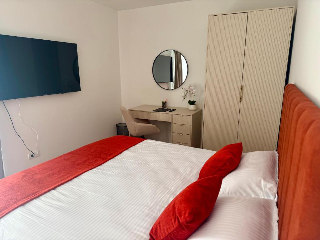 a bedroom with a bed and a desk and a mirror at IDDA Concept 3 in Târgu-Mureş