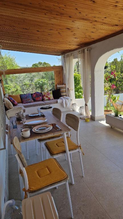 a living room with a table and chairs and a couch at Lingo garden house in Nea Irakleia