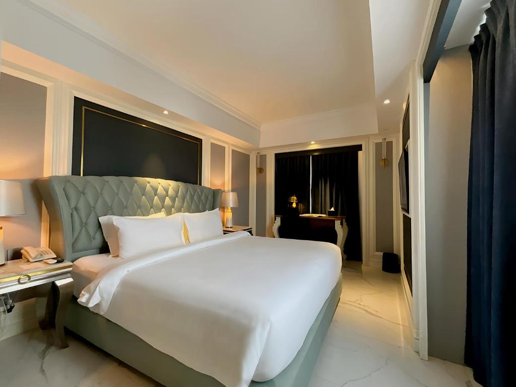a large white bed in a hotel room at Grand Eska Hotel & Suites Batam in Nagoya