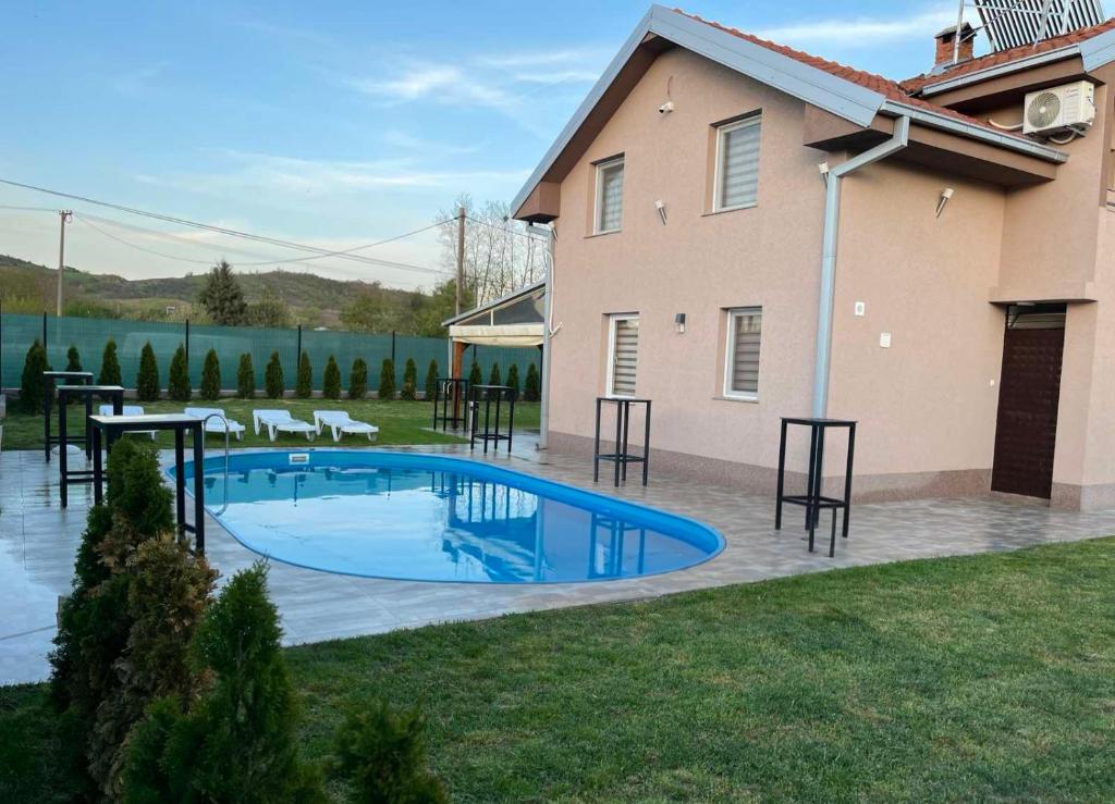 a swimming pool in a yard next to a house at Villa Gjorgjevikj in Kumanovo