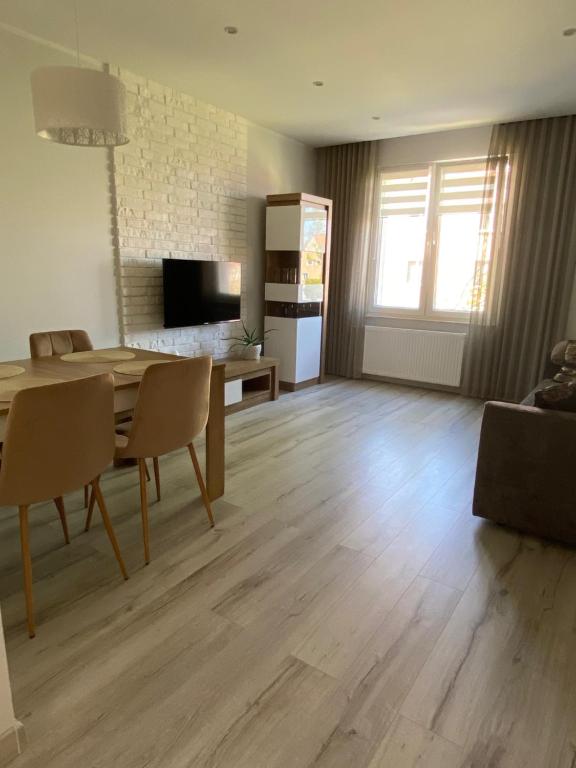 a living room with a dining table and a kitchen at Apartament DeLux WHITE Konin in Konin