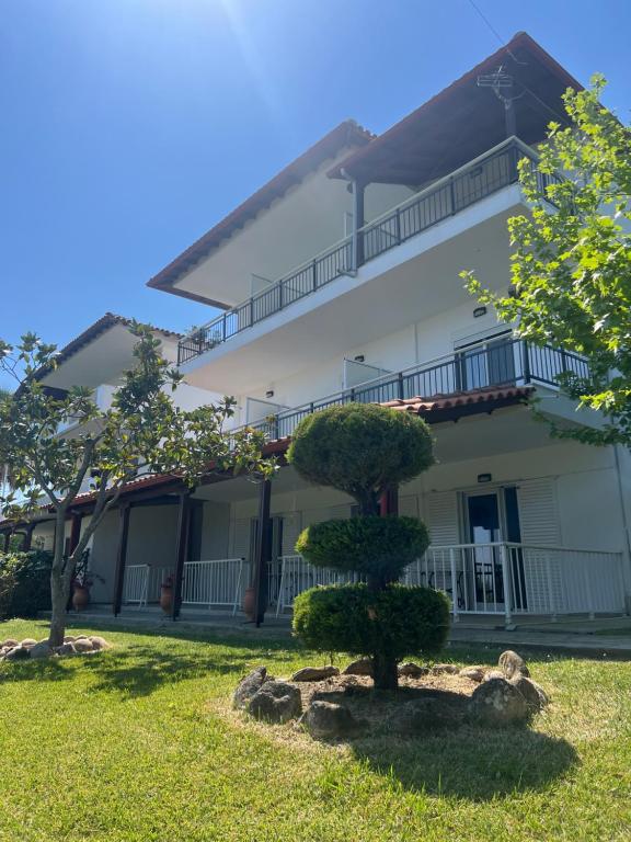 a large white building with a tree in the yard at Barbara House in Kriopigi