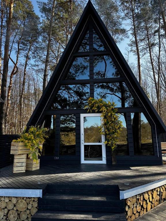a cabin with a triangular roof with a window at A-frame будиночок in Staraya Guta