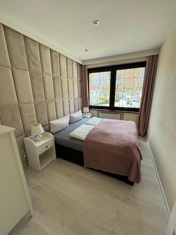 a bedroom with a large bed and a window at Willa 56 in Międzyzdroje