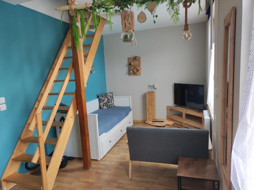 a room with a loft bed and a couch at Le Cottage des Curie in Calais